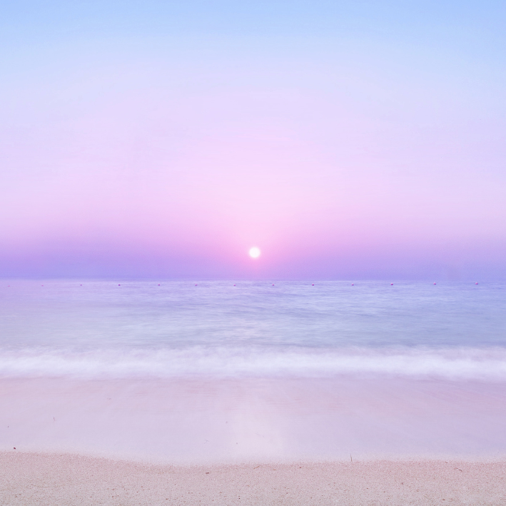 Sunset on a beach with blue and pink hues