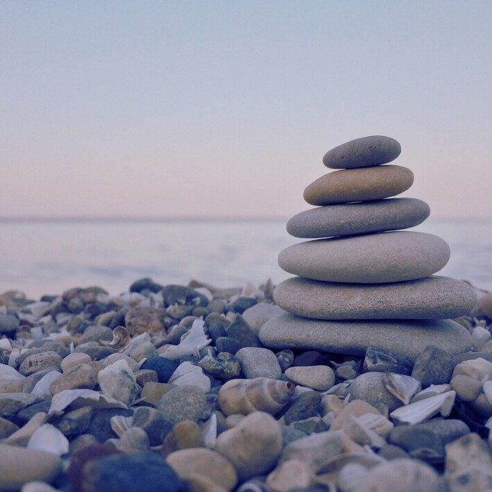 Stones stacked on a pebbled beach hypnotherapy